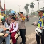 Kapolres Kotim Laksanakan Pengaturan Lalu Lintas serta Bagikan Helm kepada Masyarakat