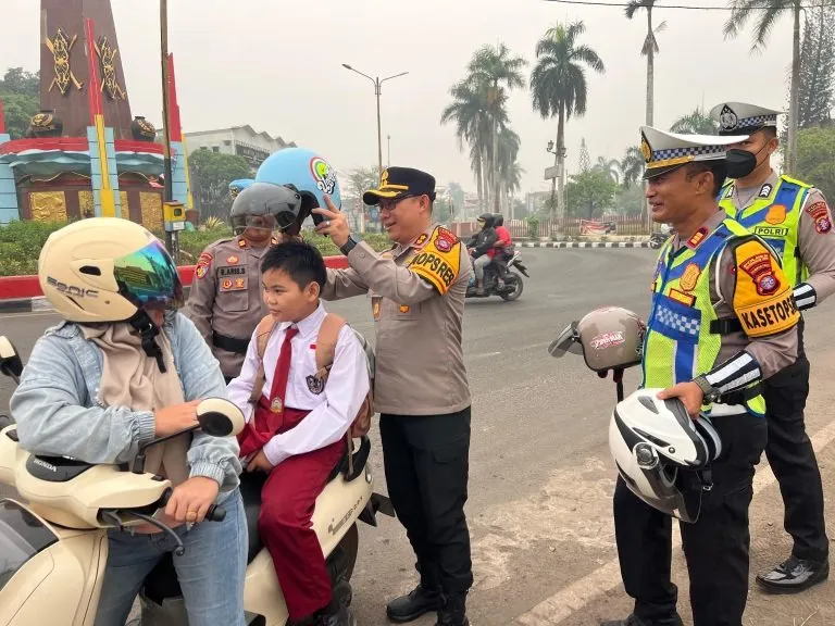 Kapolres Kotim Laksanakan Pengaturan Lalu Lintas serta Bagikan Helm kepada Masyarakat